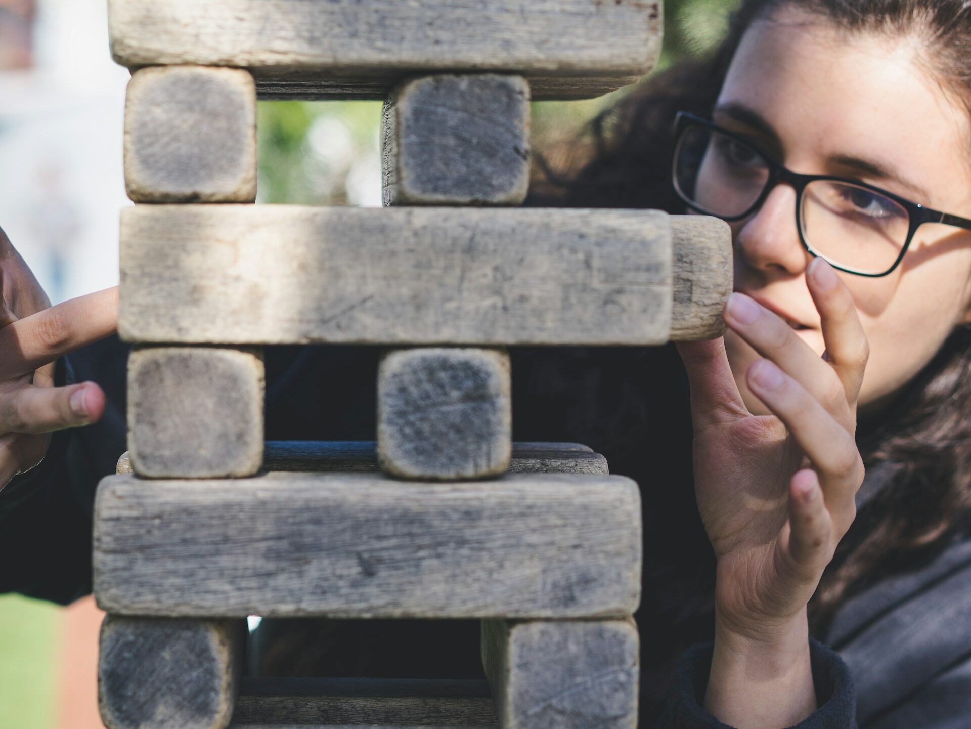 Une geek (geekette) ultra concentré devant une tour de Jenga afin d'éviter de la faire s'écrouler.